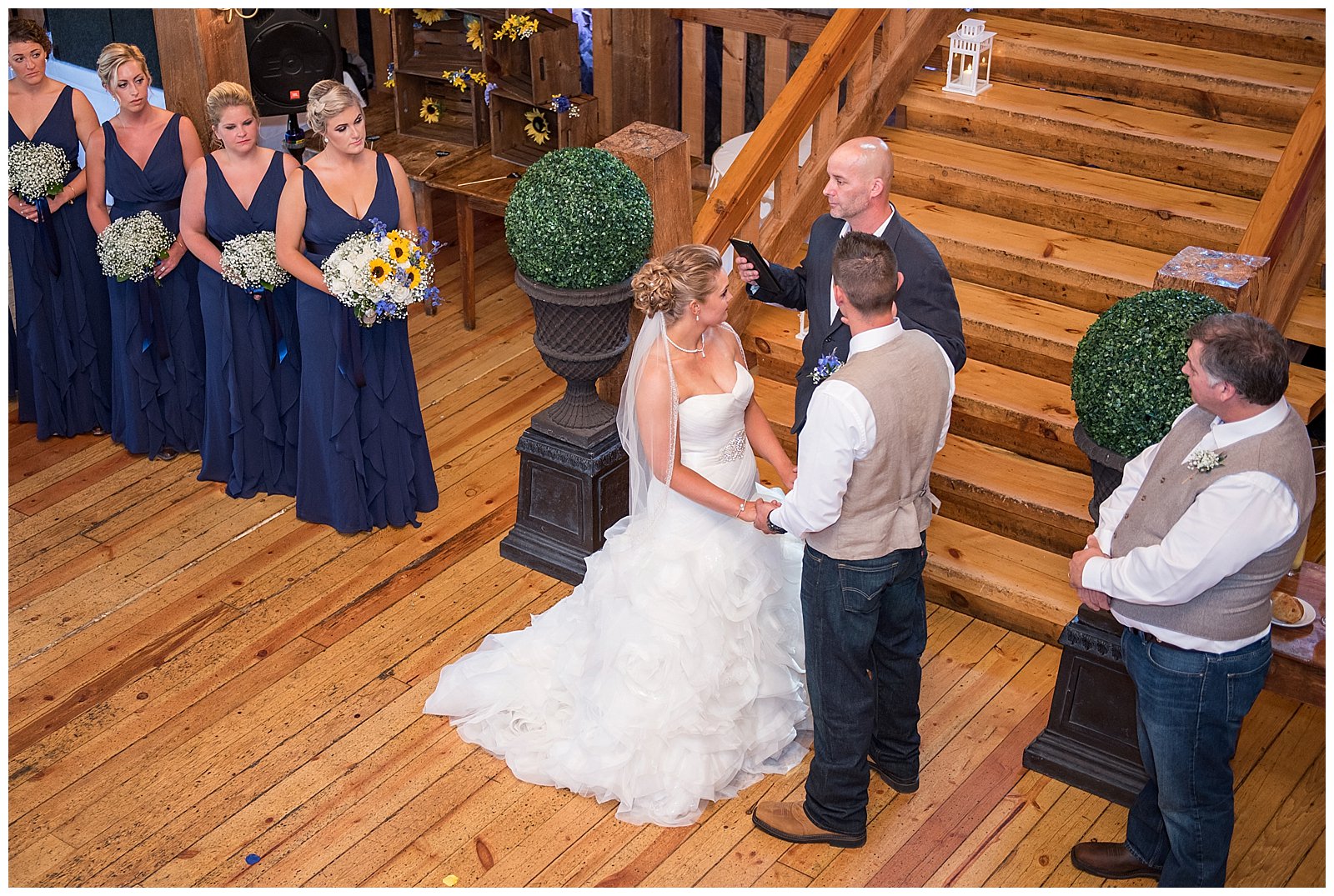 A bride and groom in the middle of their wedding ceremony in the beautiful barn of the red lion inn