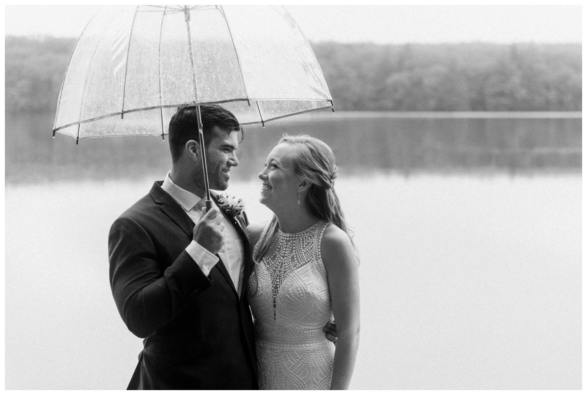 loving photo of bride and groom happy and smiling under umbrella