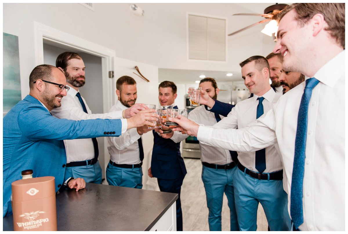groom and groomsmen cheers with whiskey before the wedding