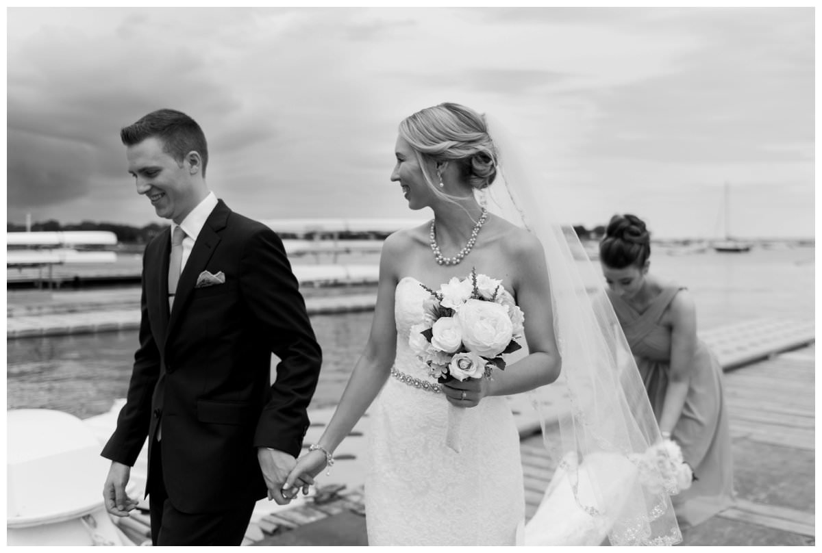 bride and groom portraits on the dock at duxbury bay maritime school as a storm rolls in