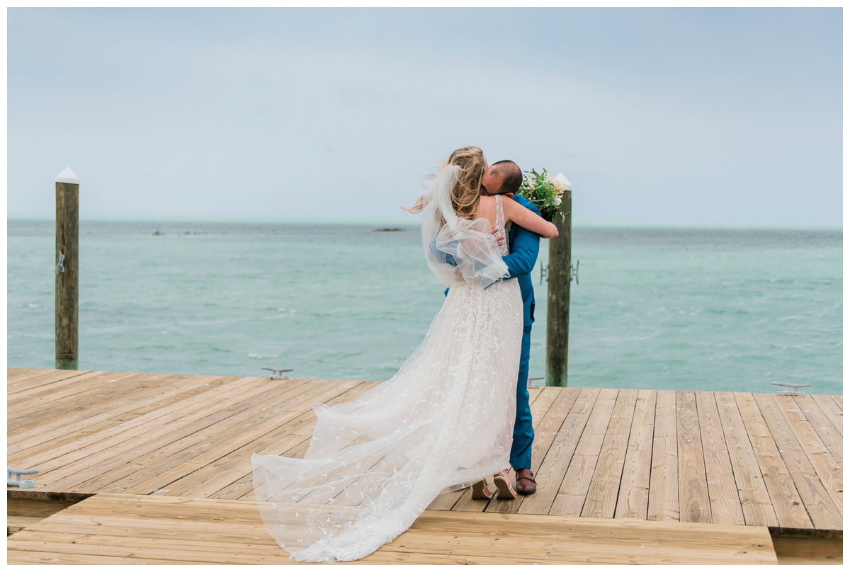 Bride and groom share a first look at the end of a pier at their amara cay resort destination florida